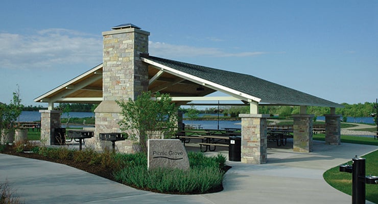 Large rectangular shelter with picnic tables and grills overlooking Crystal Lake with I-Rock columns and fireplace.