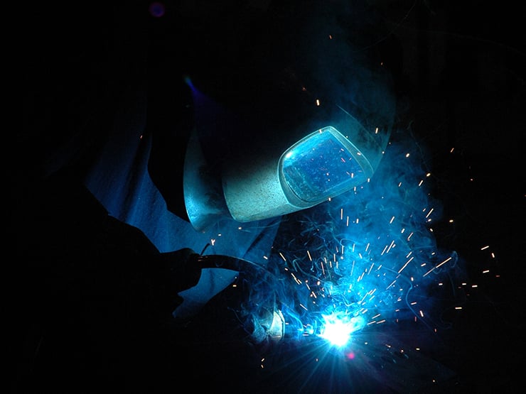 Welder with welding materials with a dark background and sparks